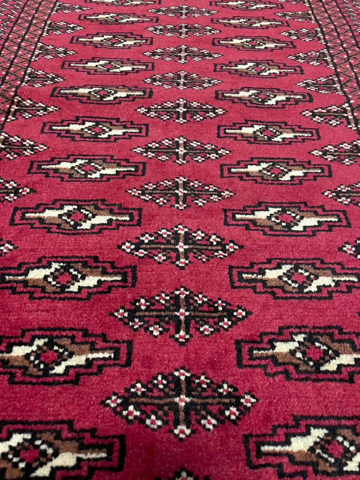 Persian rug of Turkoman style in dimensions 122 centimeters length by 80 centimeters width with mainly red colors — Texture close-up