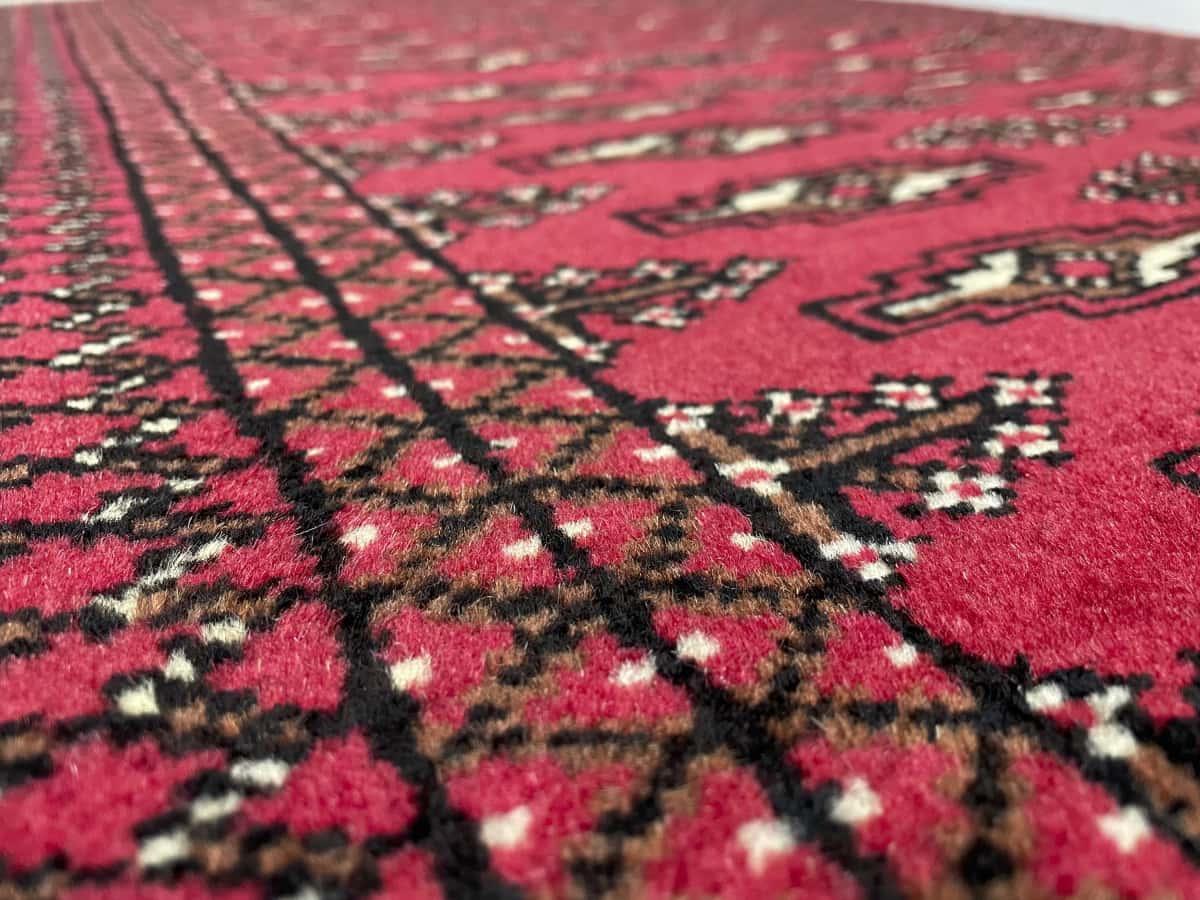 Persian rug of Turkoman style in dimensions 122 centimeters length by 80 centimeters width with mainly red colors — Texture close-up