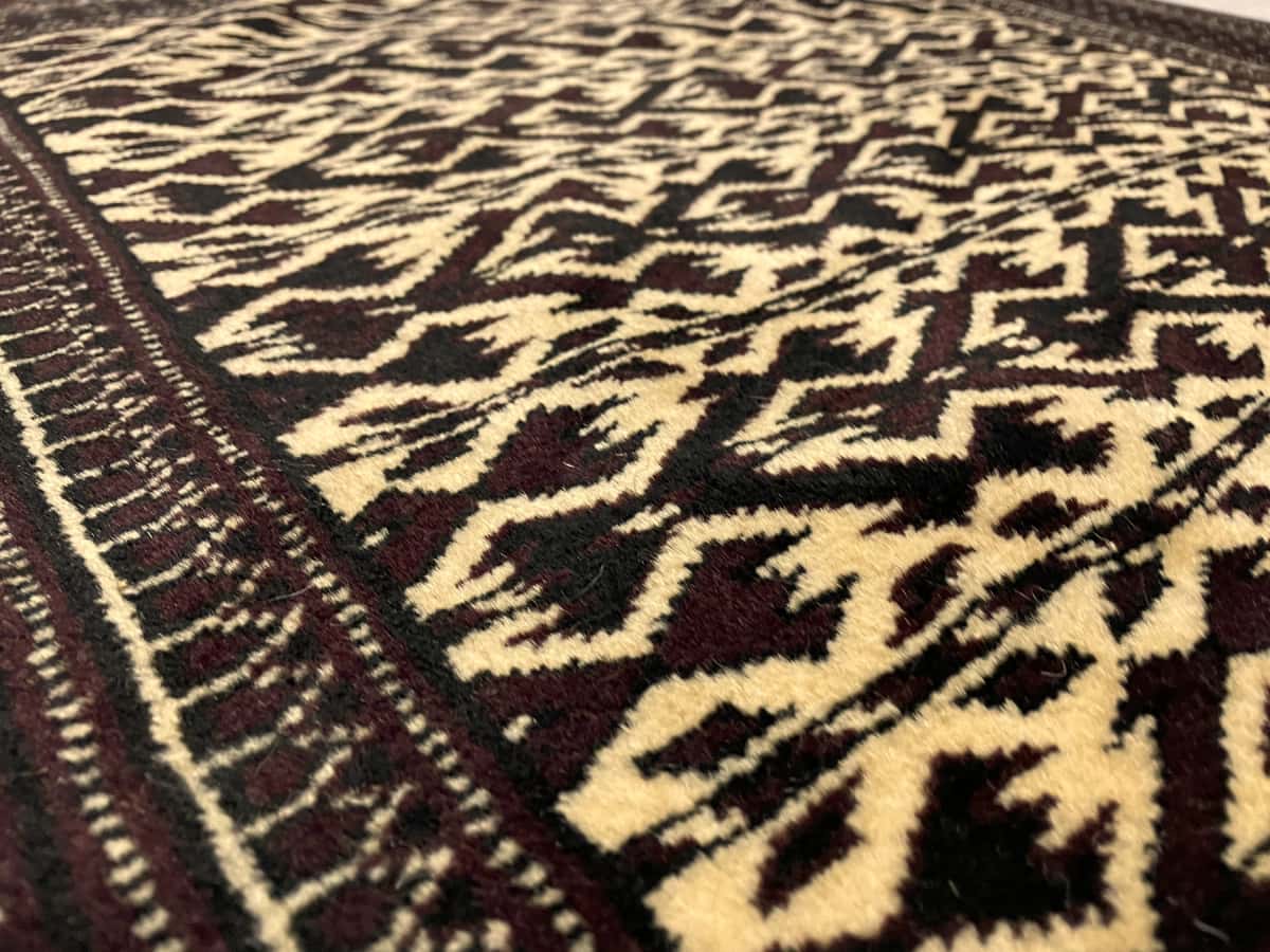 Persian rug of Turkoman style in dimensions 133 centimeters length by 94 centimeters width with mainly brown and beige colors — Texture close-up