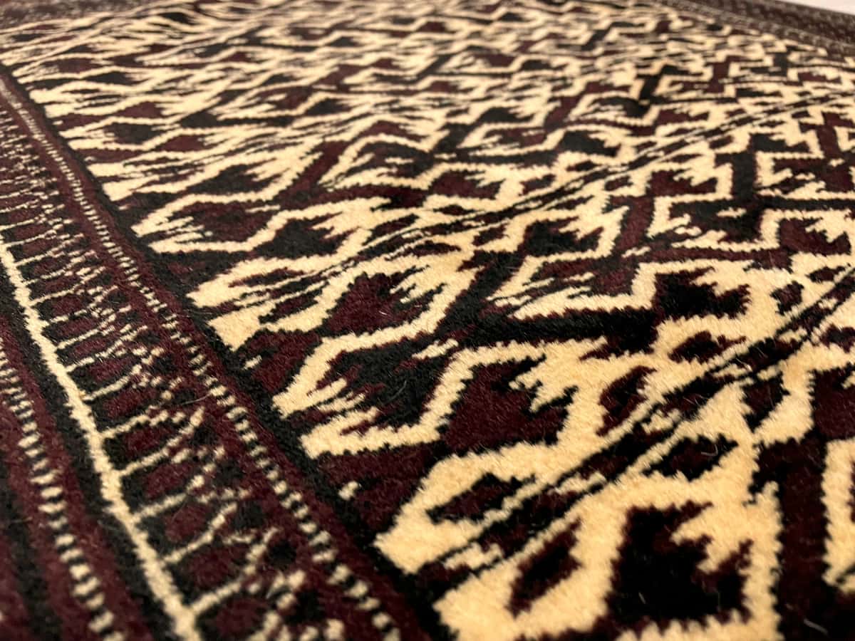 persischer Teppich im turkmenischer Stil in den Maßen 133 Zentimeter Länge mal 94 Zentimeter Breite mit überwiegend braun und gelb Farben — Nahaufnahme der Textur