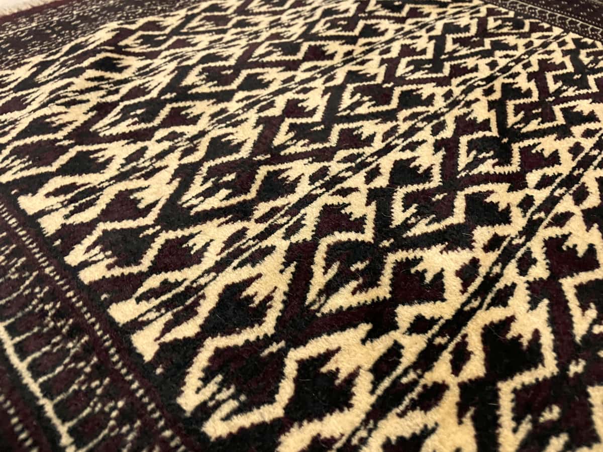 Persian rug of Turkoman style in dimensions 133 centimeters length by 94 centimeters width with mainly brown and beige colors — Texture close-up