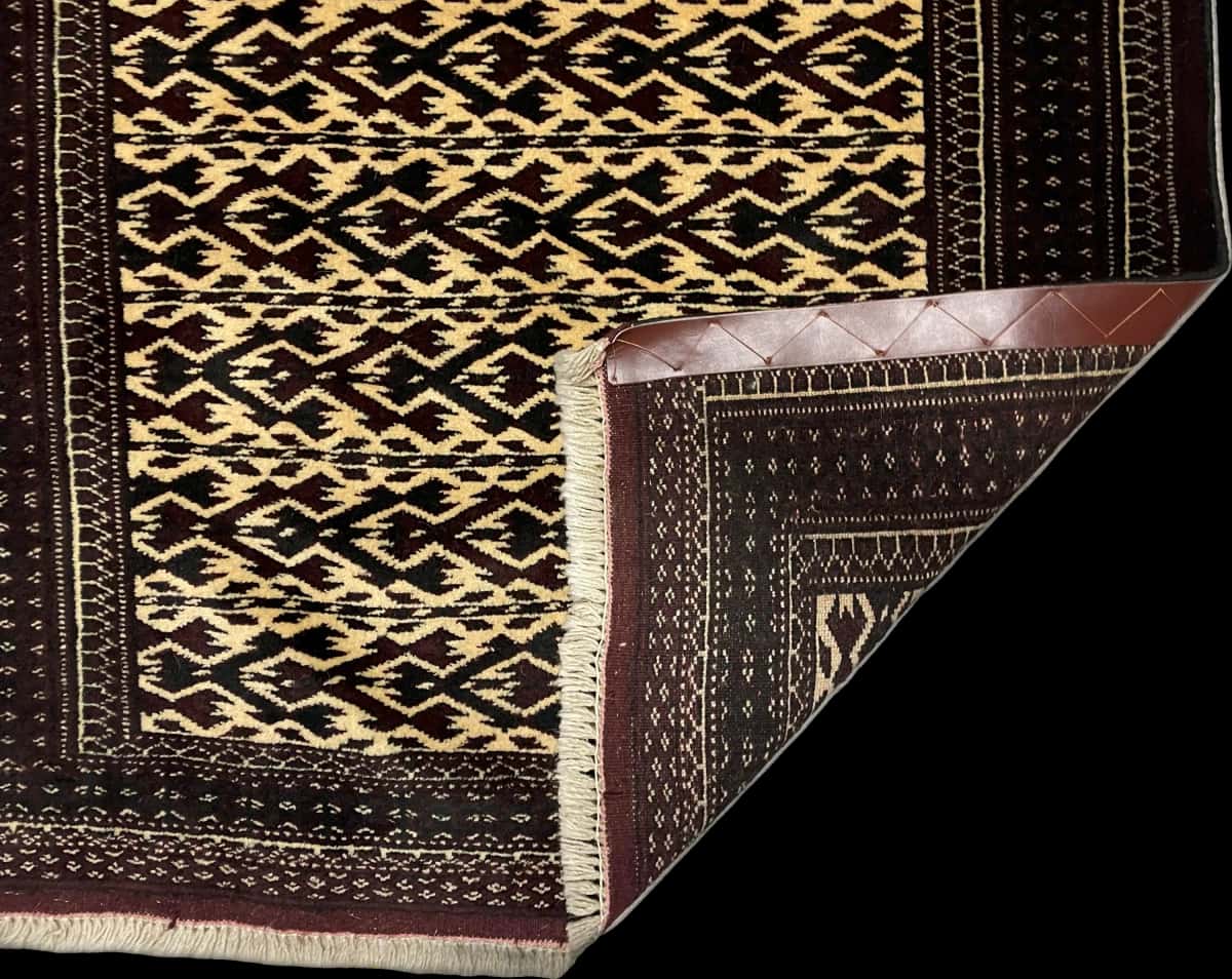 persischer Teppich im turkmenischer Stil in den Maßen 133 Zentimeter Länge mal 94 Zentimeter Breite mit überwiegend braun und gelb Farben — Gefaltet