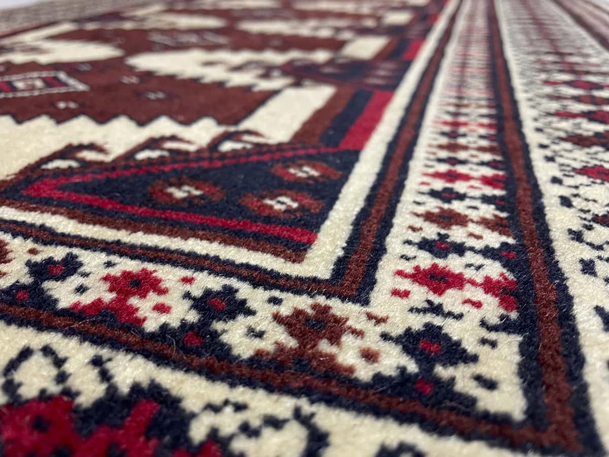 Persian rug in dimensions 112 centimeters length by 79 centimeters width with mainly beige and brown colors — Texture close-up