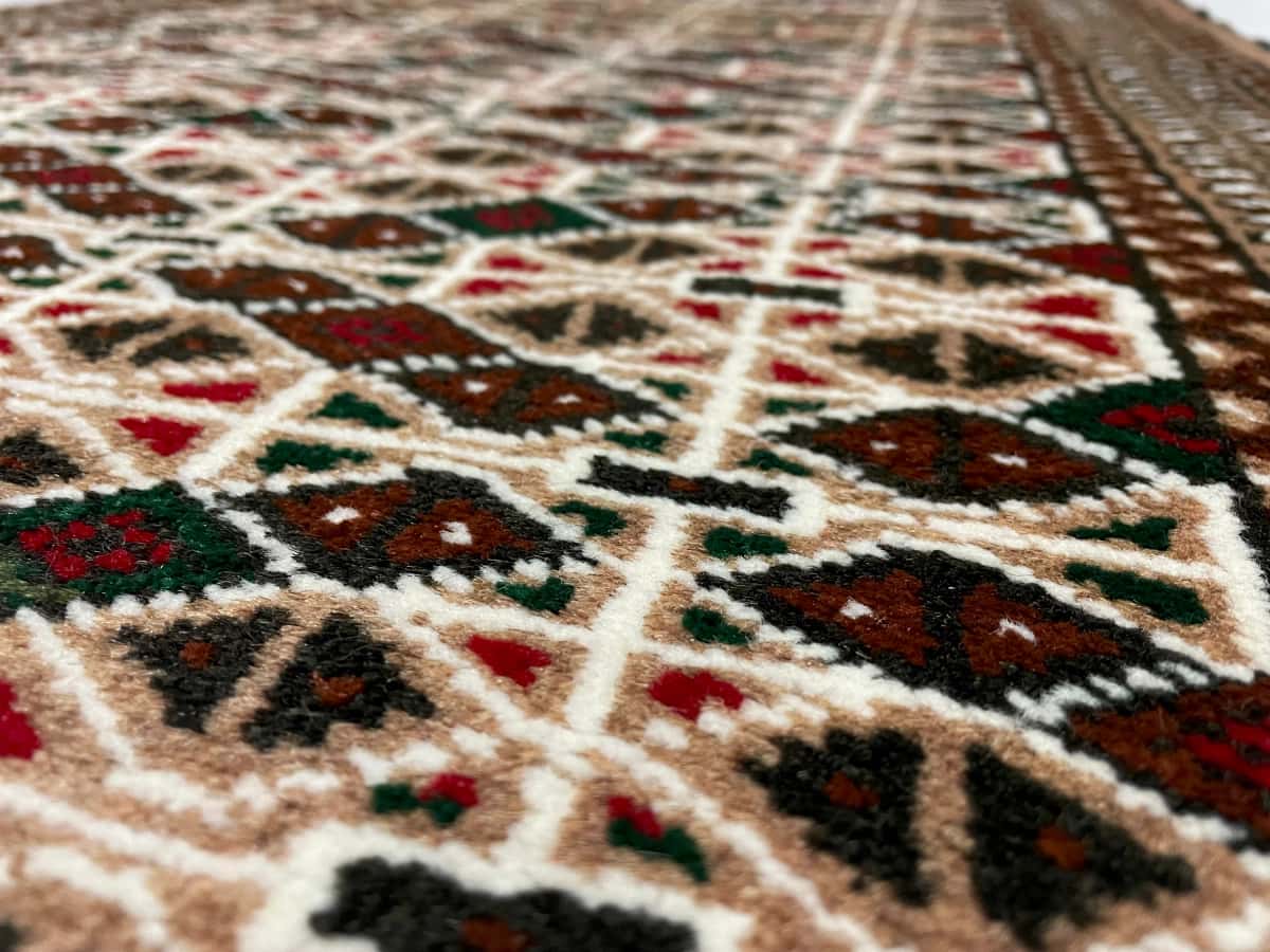 persischer Teppich im turkmenischer Stil in den Maßen 117 Zentimeter Länge mal 76 Zentimeter Breite mit überwiegend braun Farben — Nahaufnahme der Textur