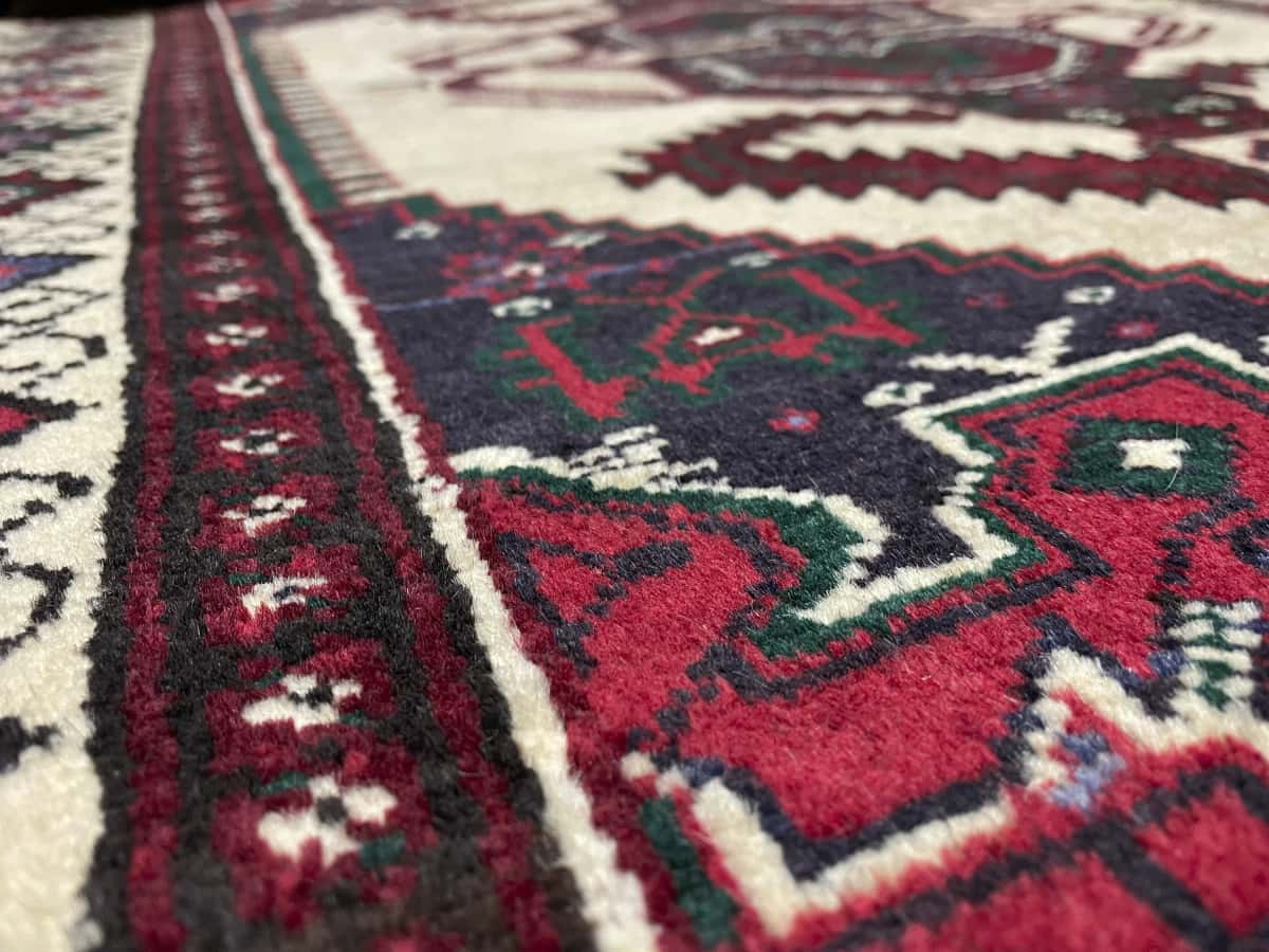 Persian rug of Turkoman style in dimensions 113 centimeters length by 90 centimeters width with mainly beige and yellow colors — Texture close-up