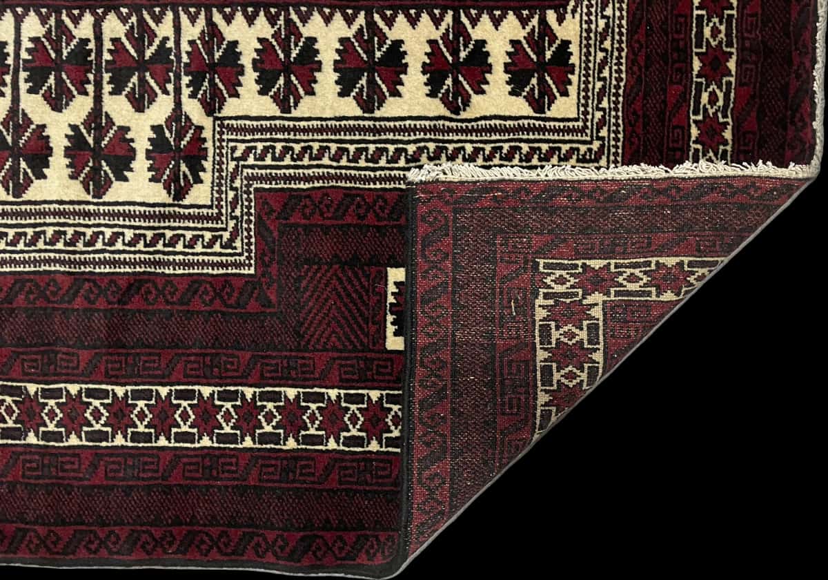 alfombra persa de estilo turcomana en dimensiones 150 centímetros de largo por 110 centímetros de ancho con colores principalmente rojo y negro — Plegada