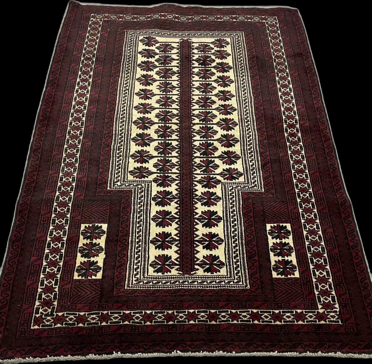 alfombra persa de estilo turcomana en dimensiones 150 centímetros de largo por 110 centímetros de ancho con colores principalmente rojo y negro — Perspectiva