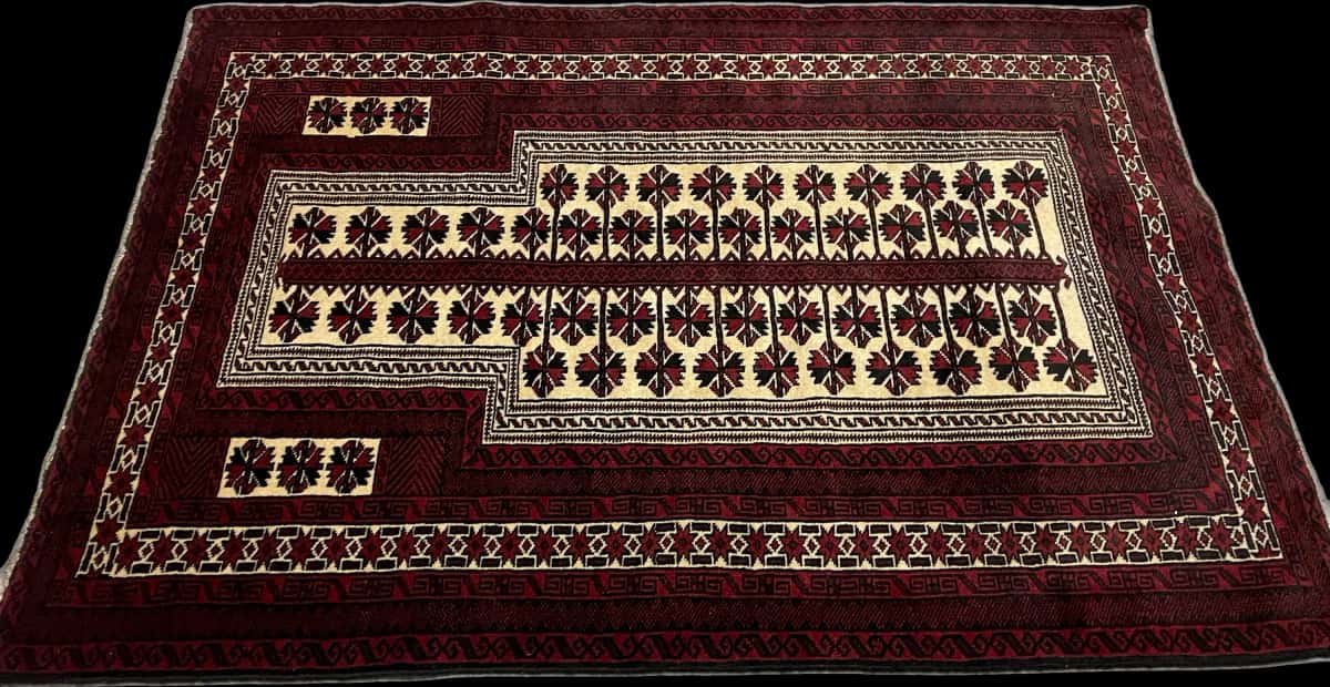 alfombra persa de estilo turcomana en dimensiones 150 centímetros de largo por 110 centímetros de ancho con colores principalmente rojo y negro — Perspectiva