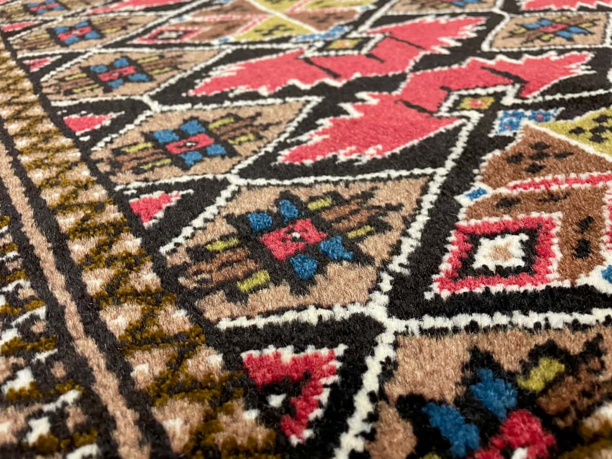 persischer Teppich im Turkmene Stil in den Maßen 140 Zentimeter Länge mal 103 Zentimeter Breite mit überwiegend Braun Farben — Nahaufnahme der Textur