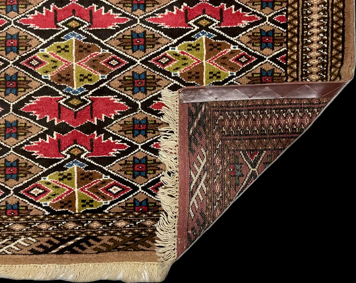 persischer Teppich im turkmenischer Stil in den Maßen 140 Zentimeter Länge mal 103 Zentimeter Breite mit überwiegend braun Farben — Gefaltet