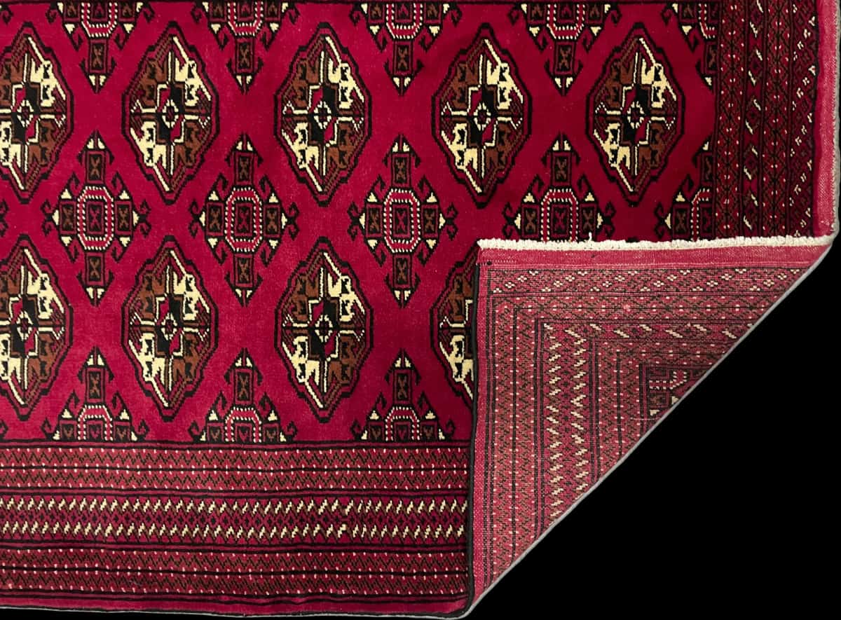 alfombra persa de estilo turcomana en dimensiones 150 centímetros de largo por 103 centímetros de ancho con colores principalmente rojo — Plegada