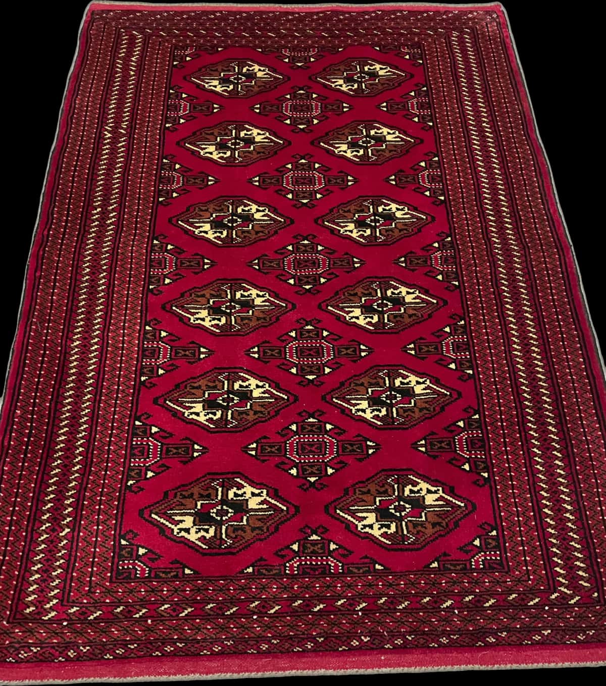 alfombra persa de estilo turcomana en dimensiones 150 centímetros de largo por 103 centímetros de ancho con colores principalmente rojo — Perspectiva