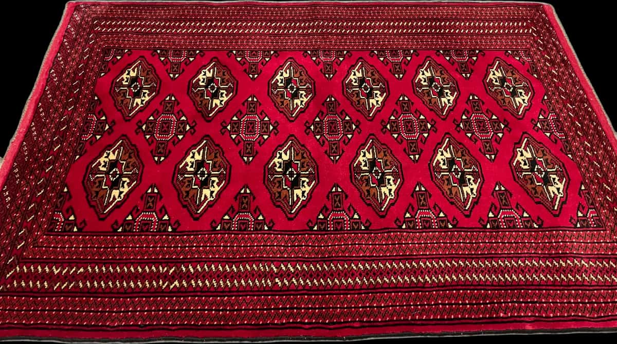 persischer Teppich im turkmenischer Stil in den Maßen 150 Zentimeter Länge mal 103 Zentimeter Breite mit überwiegend rot Farben — Perspektive