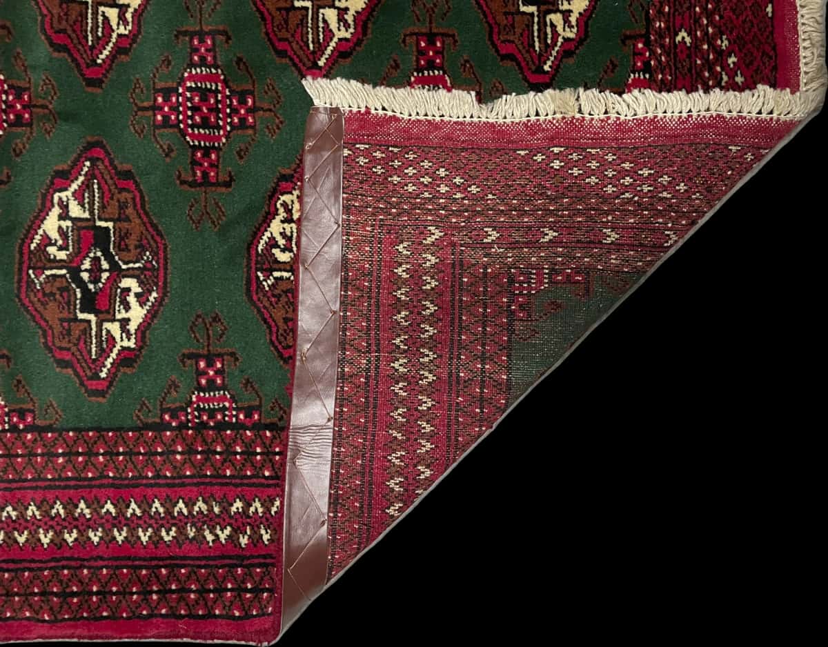 alfombra persa de estilo turcomana en dimensiones 145 centímetros de largo por 97 centímetros de ancho con colores principalmente verde — Plegada