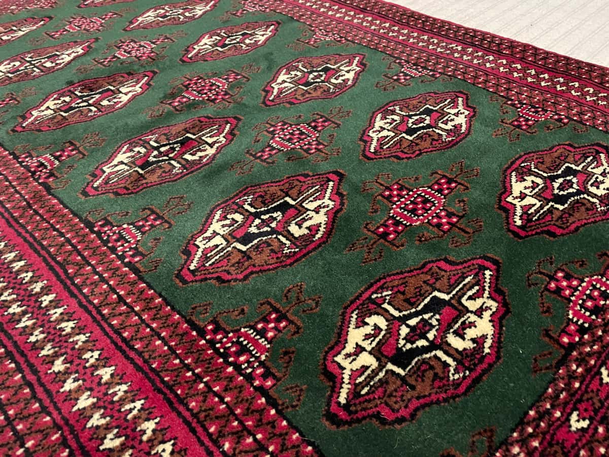 alfombra persa de estilo turcomana en dimensiones 145 centímetros de largo por 97 centímetros de ancho con colores principalmente verde — Perspectiva