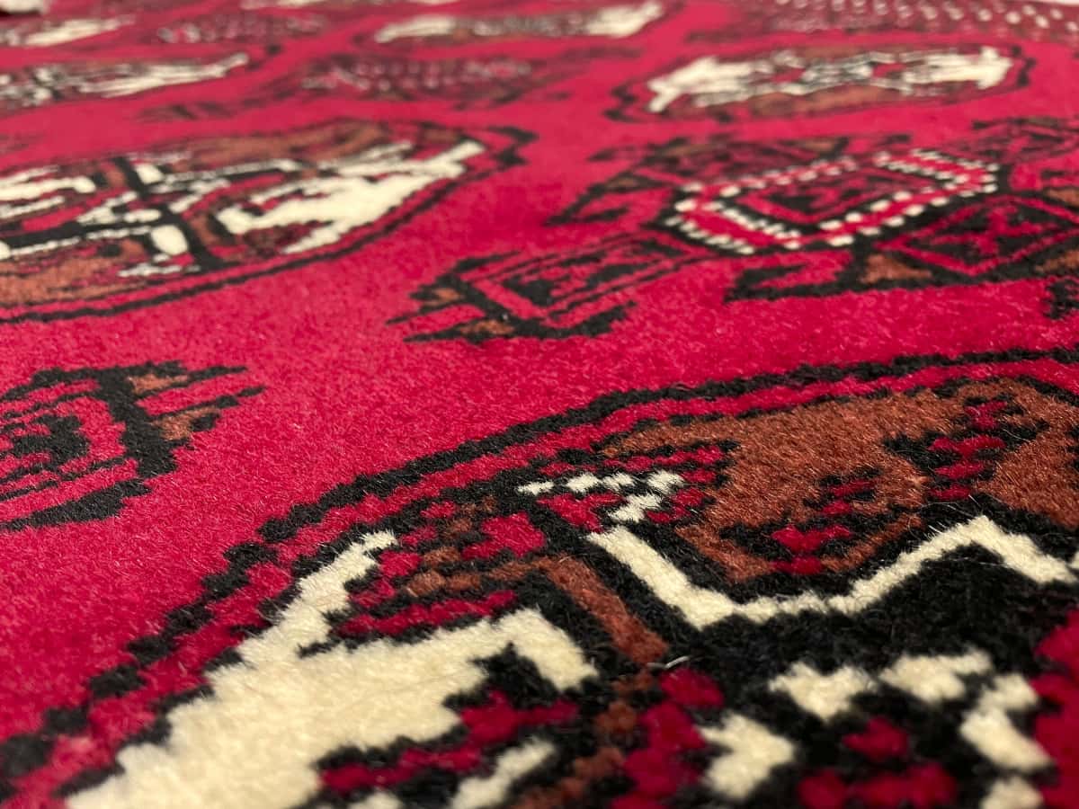 Persian rug of Turkoman style in dimensions 149 centimeters length by 98 centimeters width with mainly red colors — Texture close-up