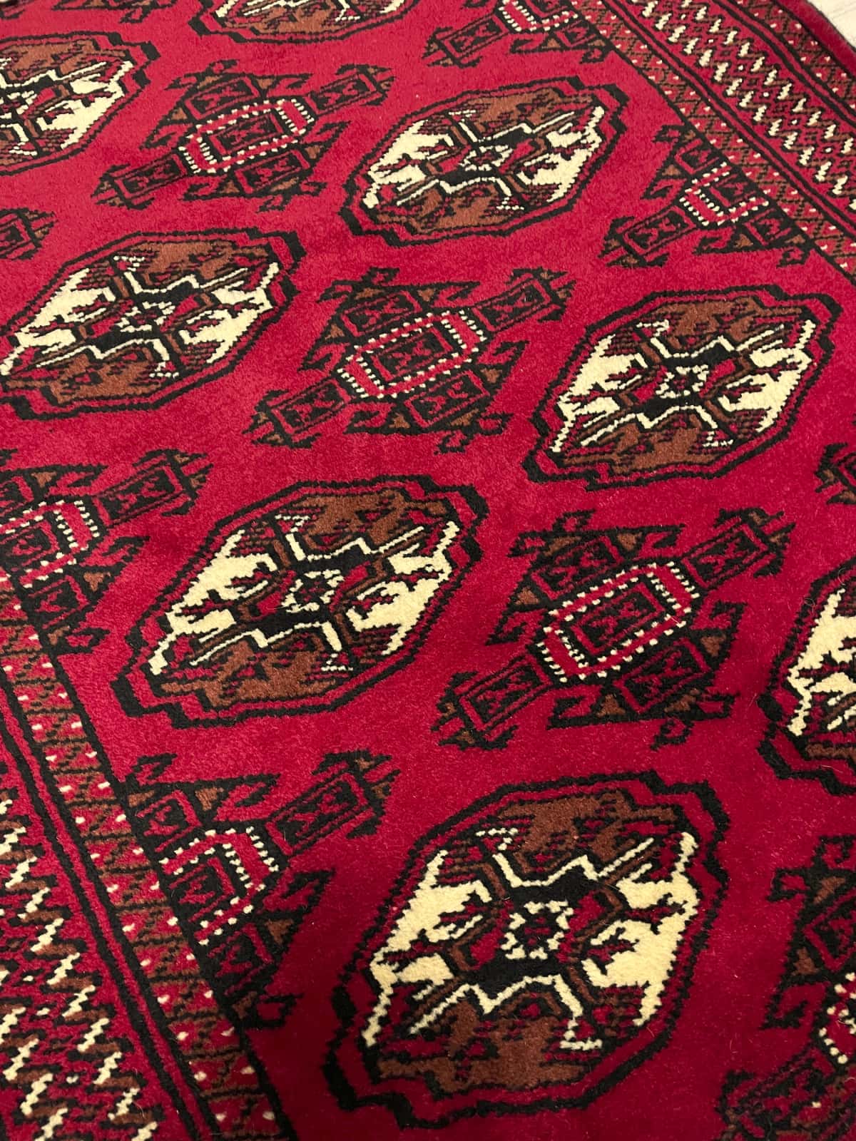 Persian rug of Turkoman style in dimensions 149 centimeters length by 98 centimeters width with mainly red colors — Texture close-up