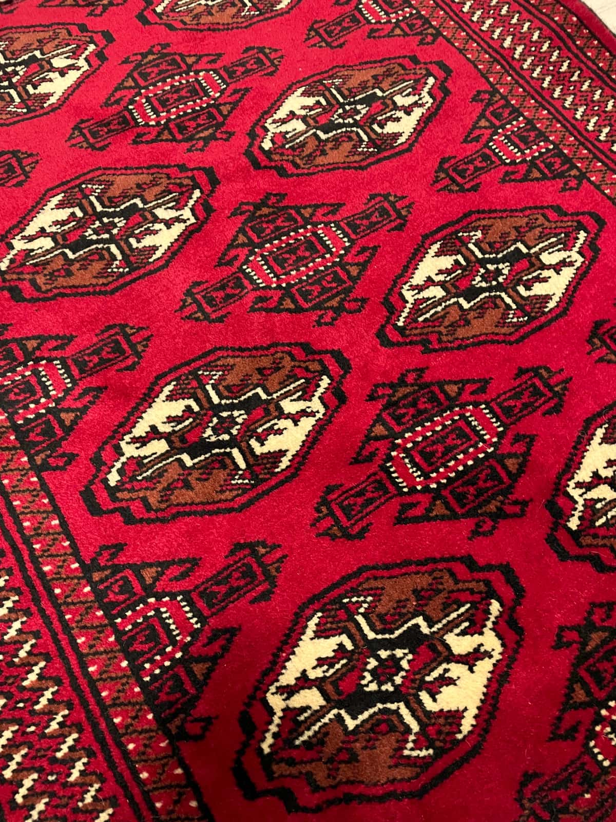 persischer Teppich im turkmenischer Stil in den Maßen 149 Zentimeter Länge mal 98 Zentimeter Breite mit überwiegend rot Farben — Nahaufnahme der Textur