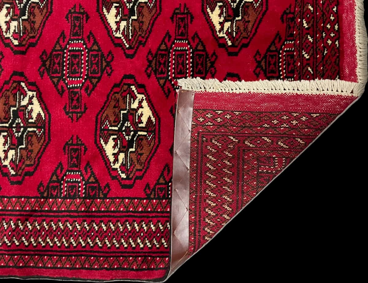 persischer Teppich im turkmenischer Stil in den Maßen 149 Zentimeter Länge mal 98 Zentimeter Breite mit überwiegend rot Farben — Gefaltet