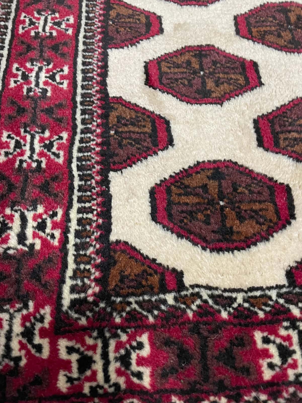 Persian rug of Turkoman style in dimensions 165 centimeters length by 105 centimeters width with mainly beige and brown colors — Texture close-up
