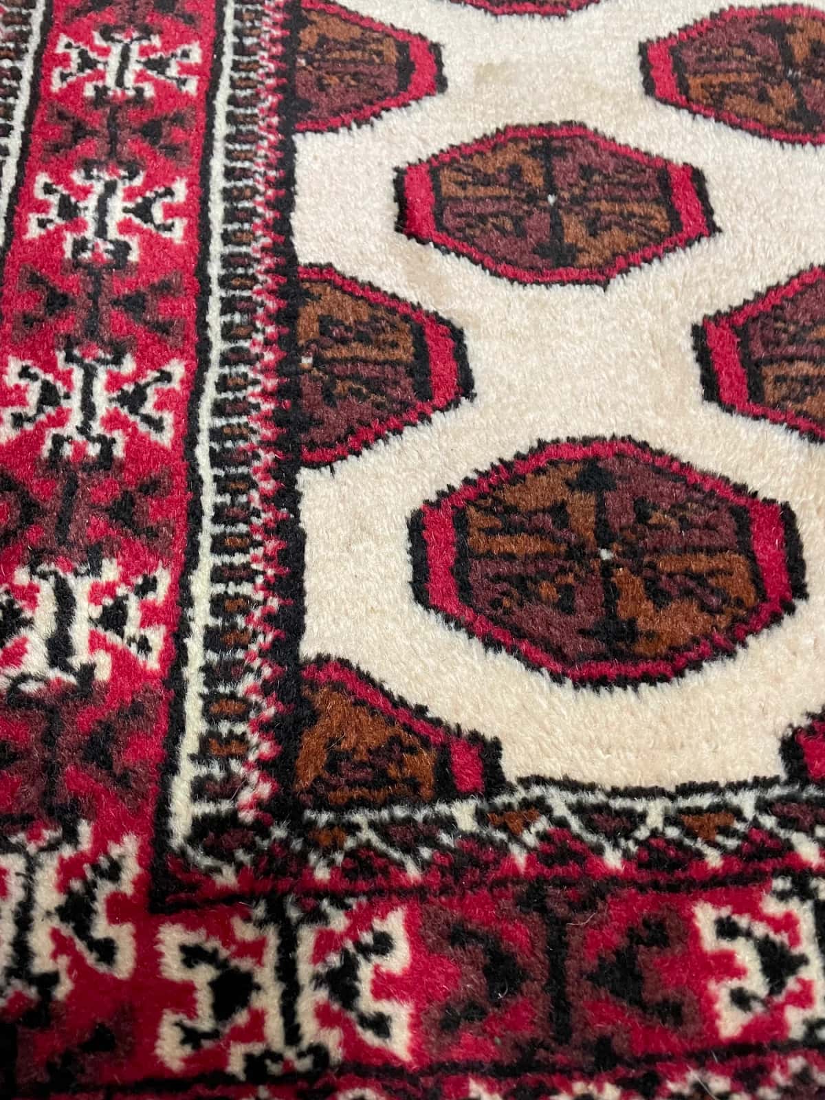 persischer Teppich im turkmenischer Stil in den Maßen 165 Zentimeter Länge mal 105 Zentimeter Breite mit überwiegend beige und braun Farben — Nahaufnahme der Textur