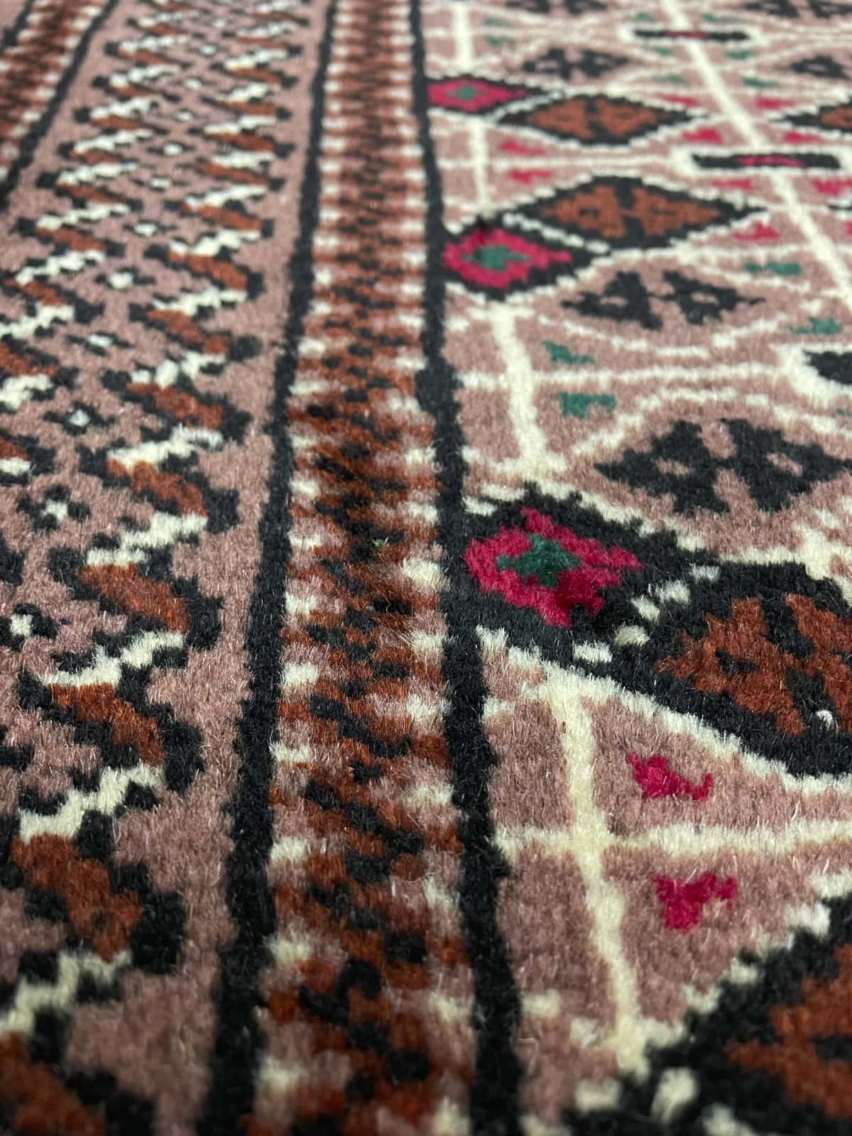 Persian rug of Turkoman style in dimensions 142 centimeters length by 98 centimeters width with mainly brown colors — Texture close-up