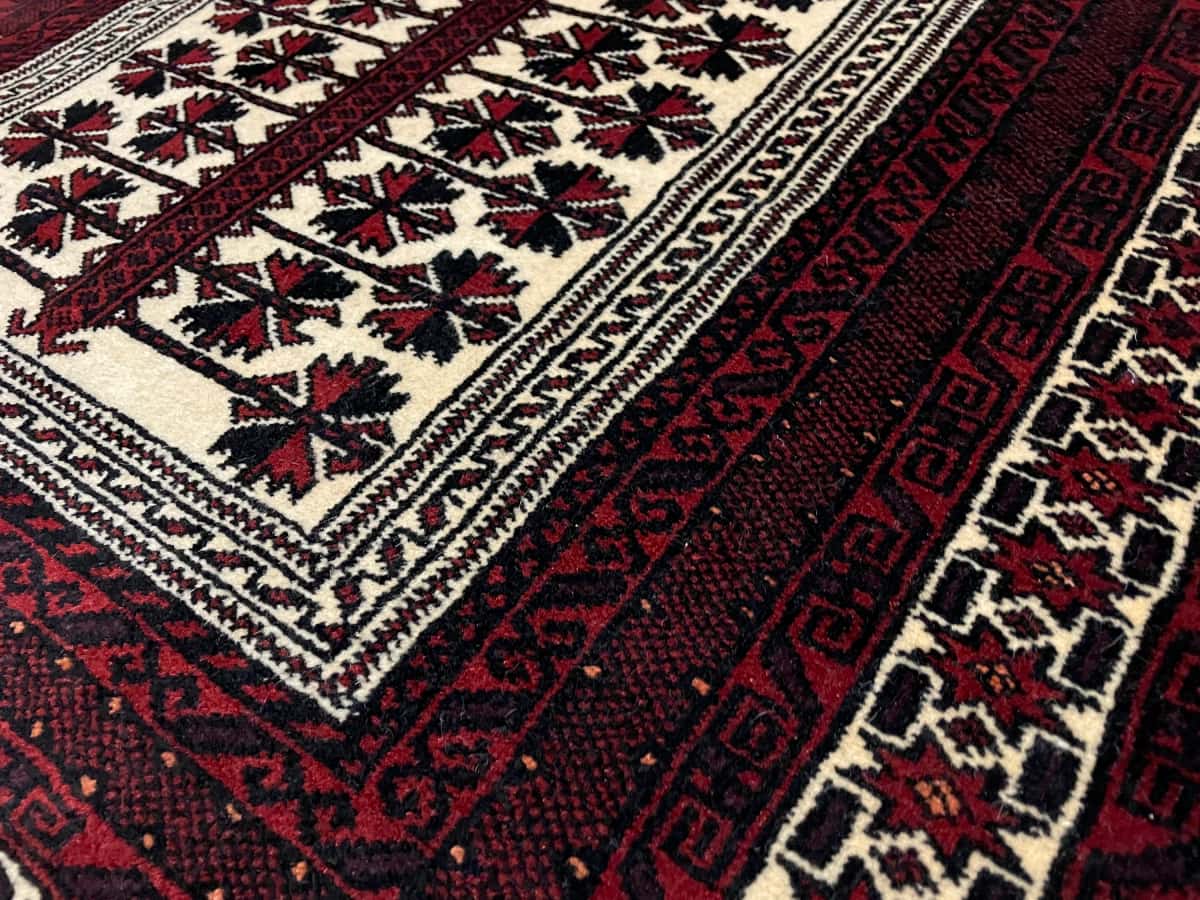 Persian rug of Turkoman style in dimensions 158 centimeters length by 106 centimeters width with mainly red and beige colors — Texture close-up