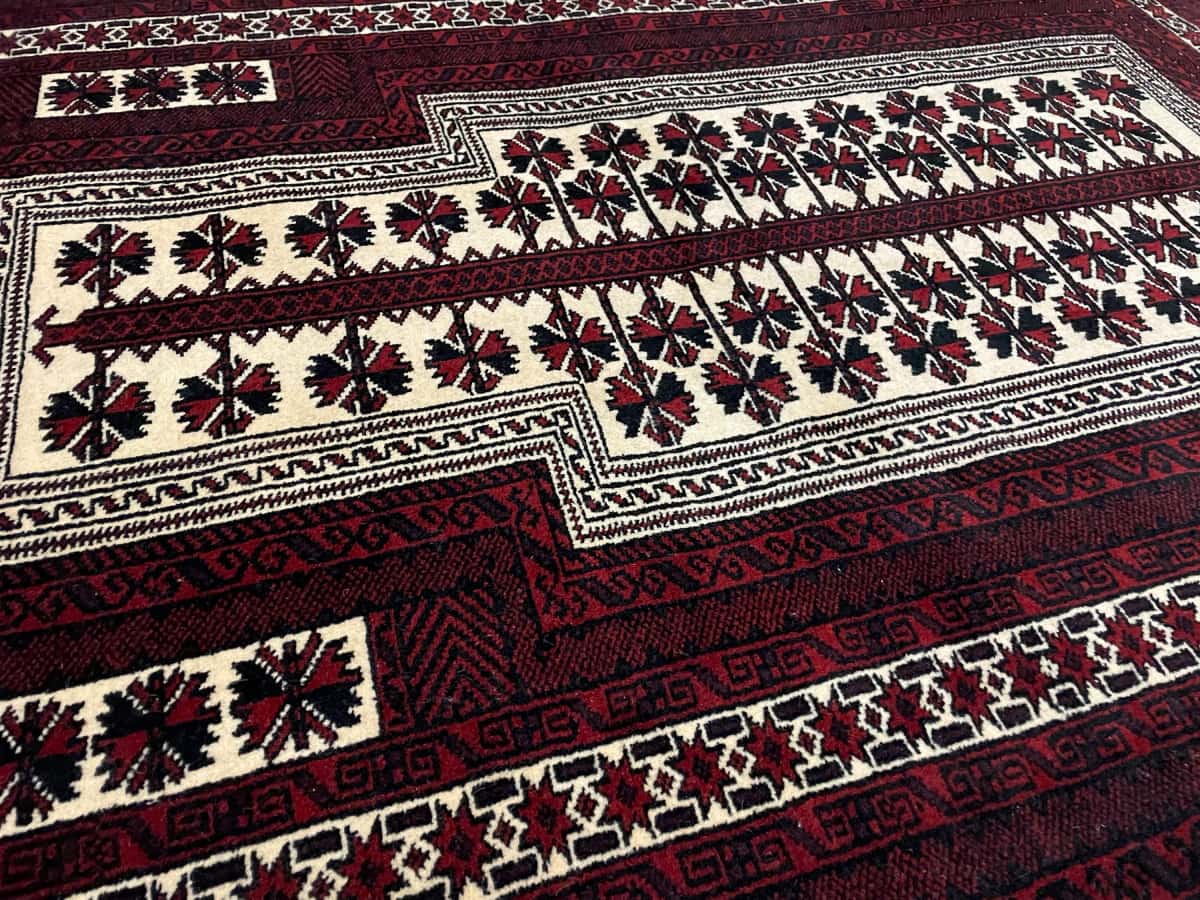 Persian rug of Turkoman style in dimensions 158 centimeters length by 106 centimeters width with mainly red and beige colors — Texture close-up