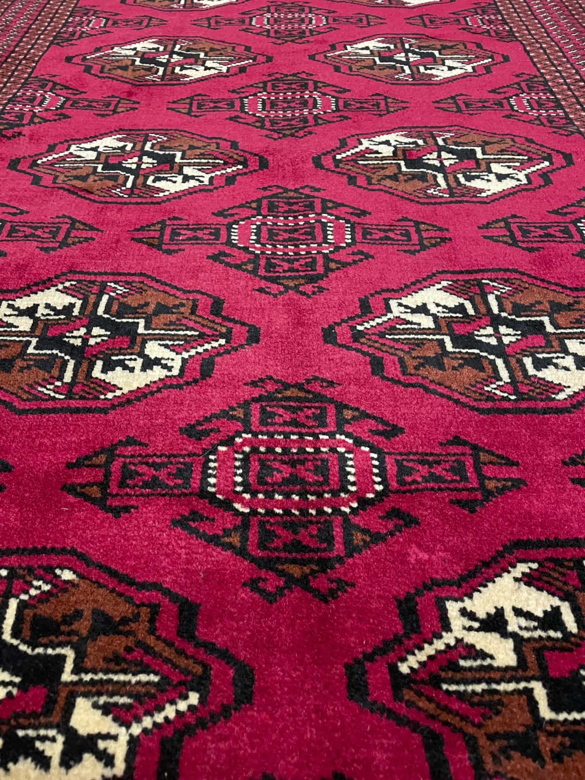 Persian rug of Turkoman style in dimensions 147 centimeters length by 98 centimeters width with mainly red colors — Texture close-up