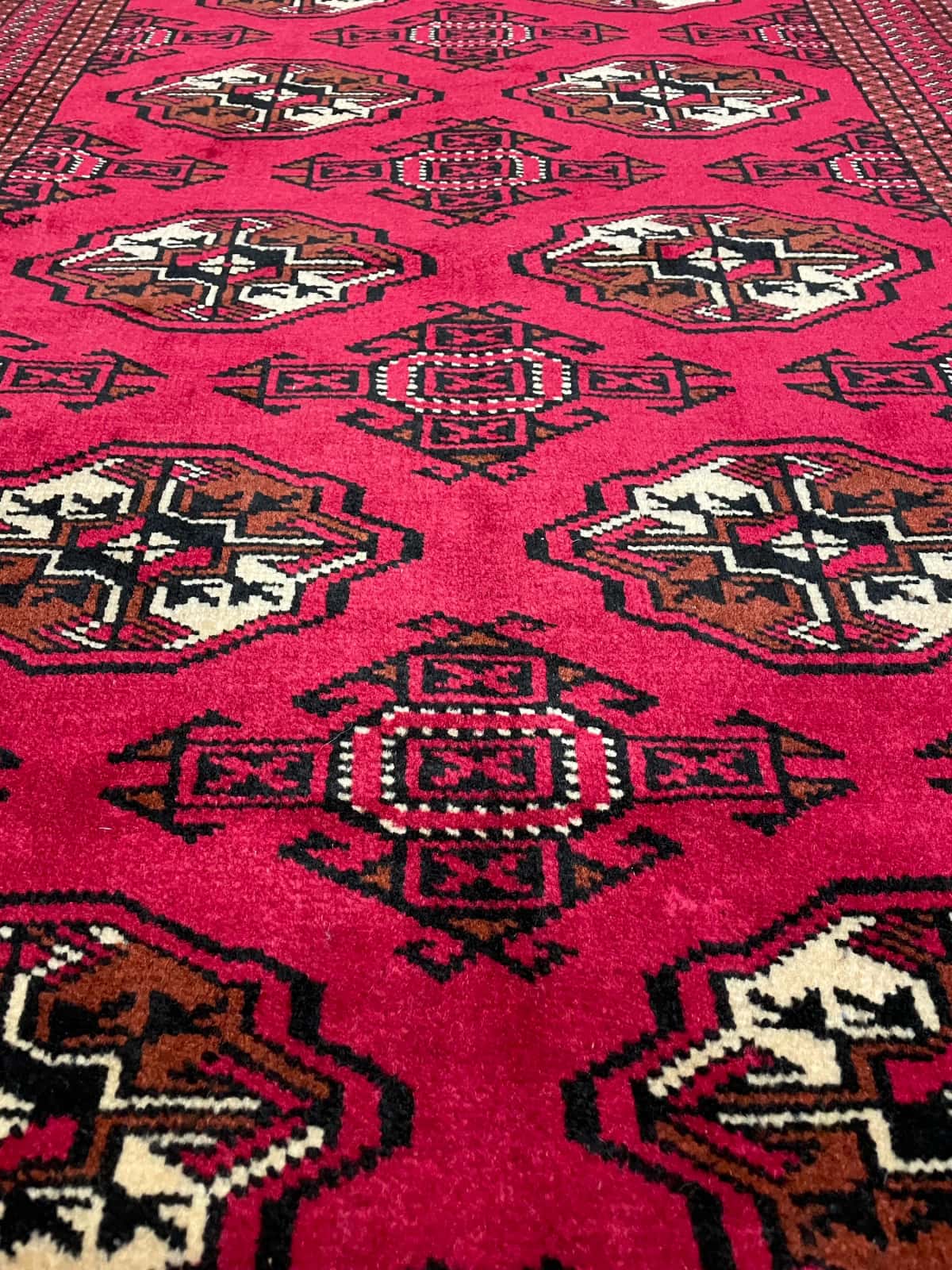 persischer Teppich im turkmenischer Stil in den Maßen 147 Zentimeter Länge mal 98 Zentimeter Breite mit überwiegend rot Farben — Nahaufnahme der Textur