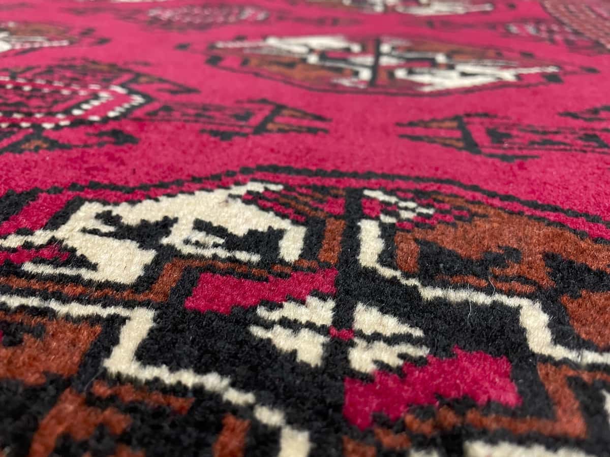 Persian rug of Turkoman style in dimensions 147 centimeters length by 98 centimeters width with mainly red colors — Texture close-up