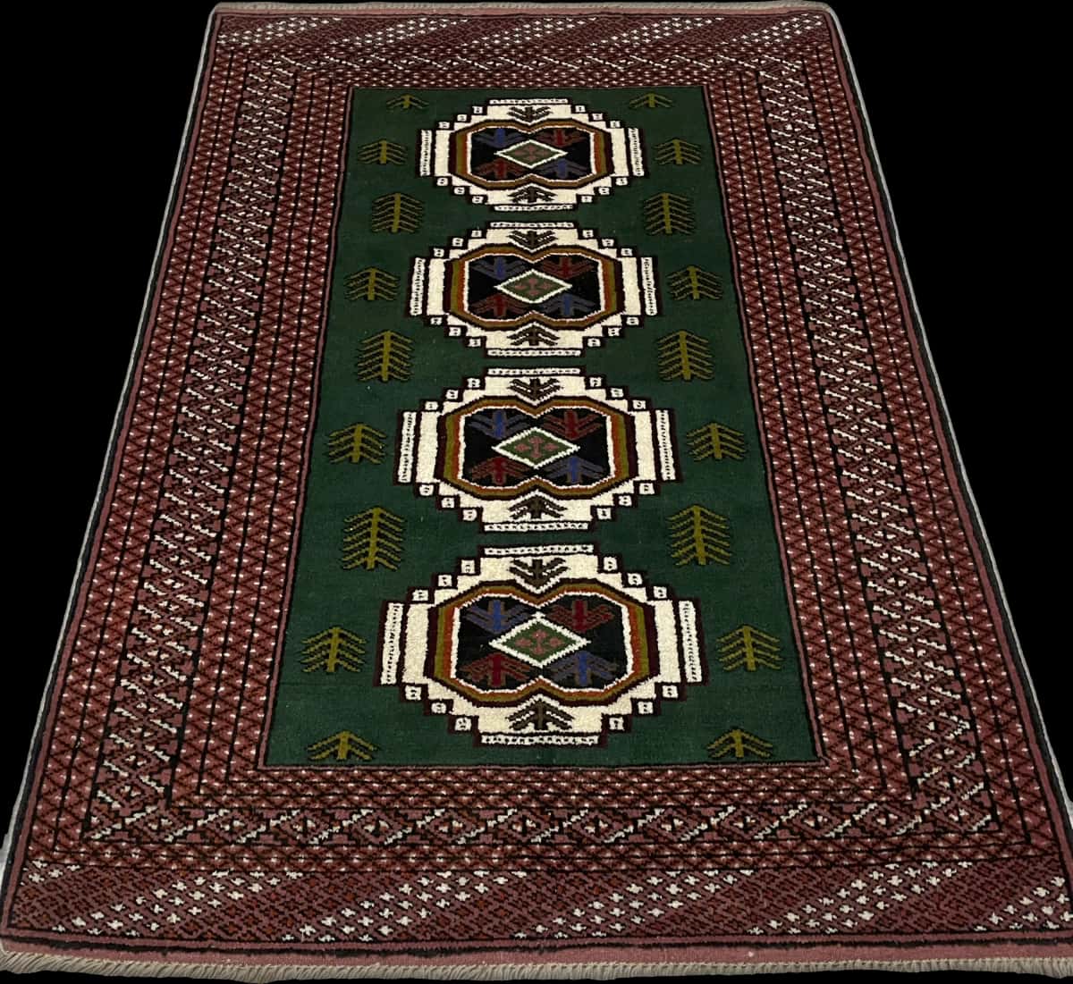 alfombra persa de estilo turcomana en dimensiones 145 centímetros de largo por 100 centímetros de ancho con colores principalmente verde — Perspectiva