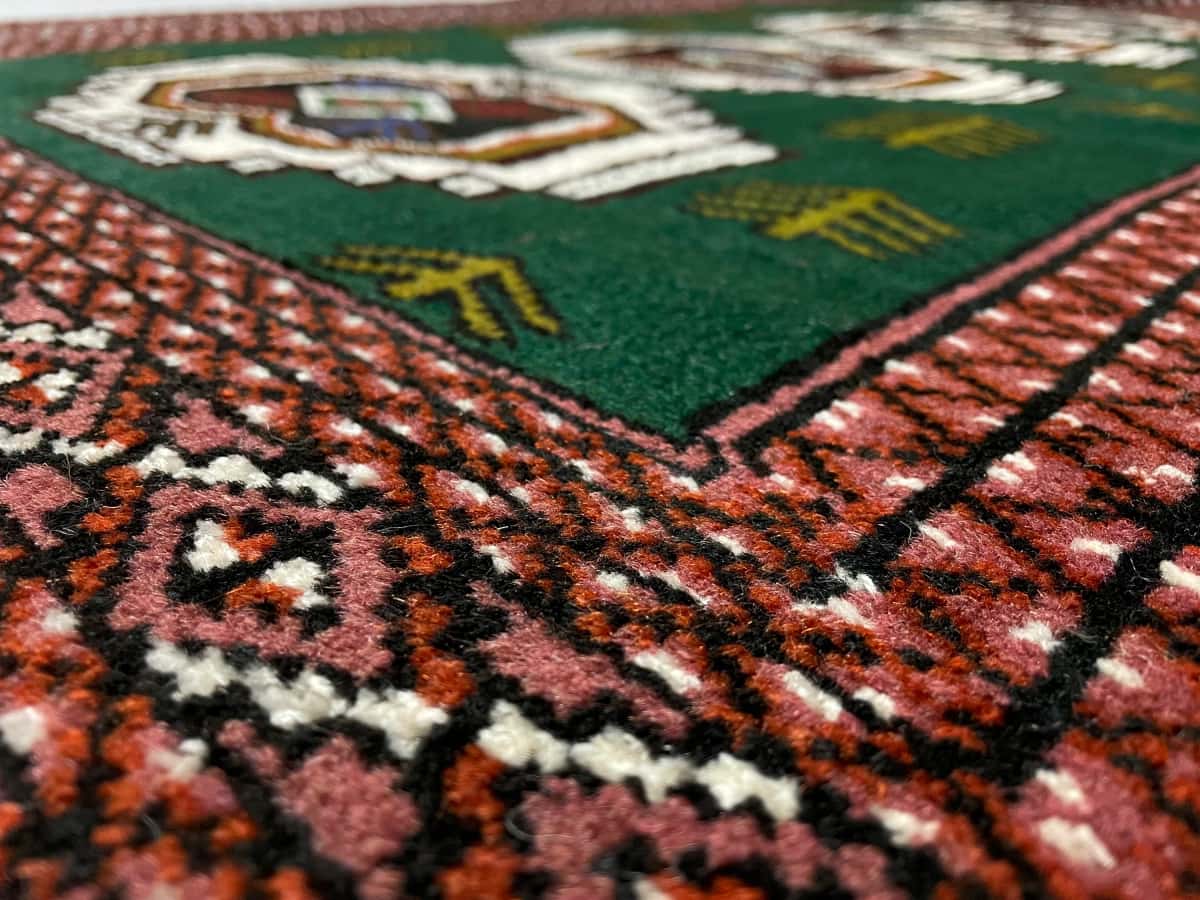 Persian rug of Turkoman style in dimensions 145 centimeters length by 100 centimeters width with mainly green colors — Texture close-up