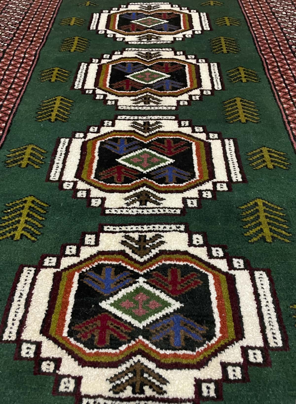 alfombra persa de estilo turcomana en dimensiones 145 centímetros de largo por 100 centímetros de ancho con colores principalmente verde — Perspectiva