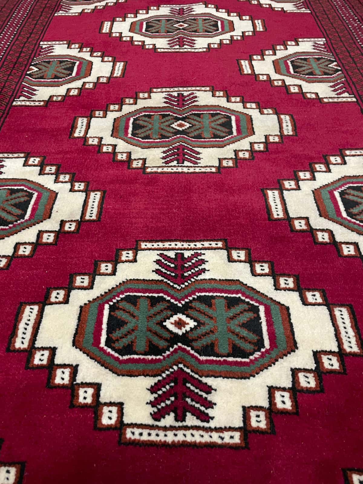 Persian rug of Turkoman style in dimensions 147 centimeters length by 105 centimeters width with mainly red colors — Texture close-up