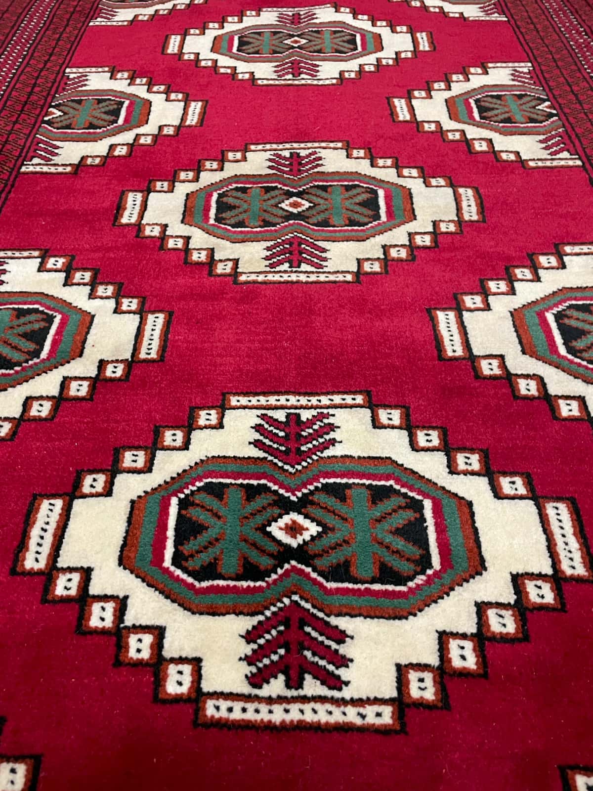 persischer Teppich im turkmenischer Stil in den Maßen 147 Zentimeter Länge mal 105 Zentimeter Breite mit überwiegend rot Farben — Nahaufnahme der Textur