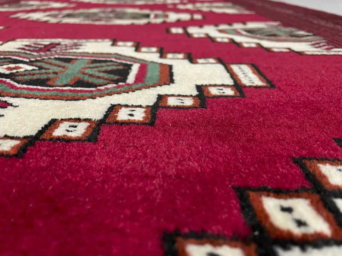 Persian rug of Turkoman style in dimensions 147 centimeters length by 105 centimeters width with mainly red colors — Texture close-up