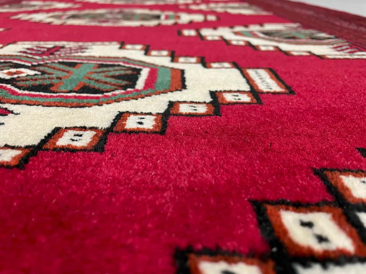 persischer Teppich im turkmenischer Stil in den Maßen 147 Zentimeter Länge mal 105 Zentimeter Breite mit überwiegend rot Farben — Nahaufnahme der Textur