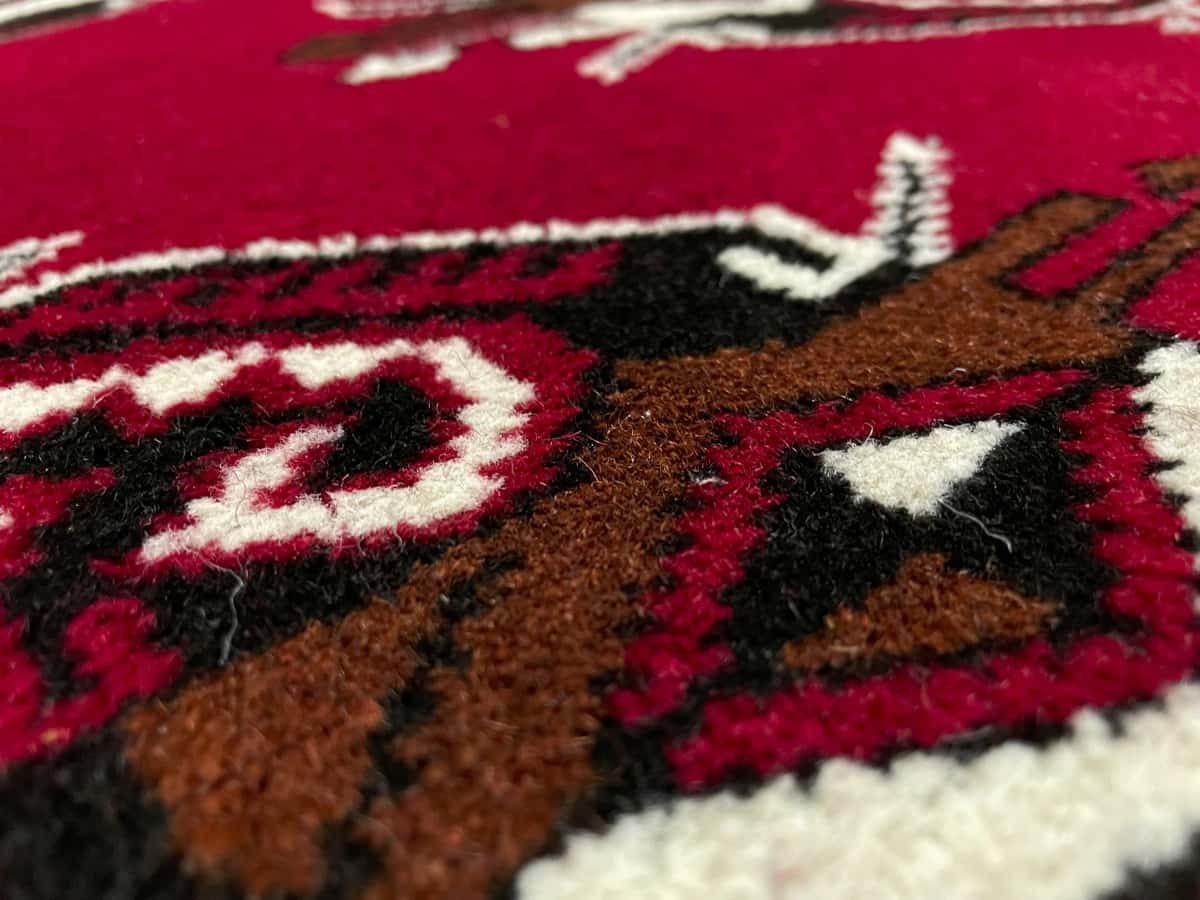 Persian rug of Turkoman style in dimensions 150 centimeters length by 98 centimeters width with mainly red colors — Texture close-up