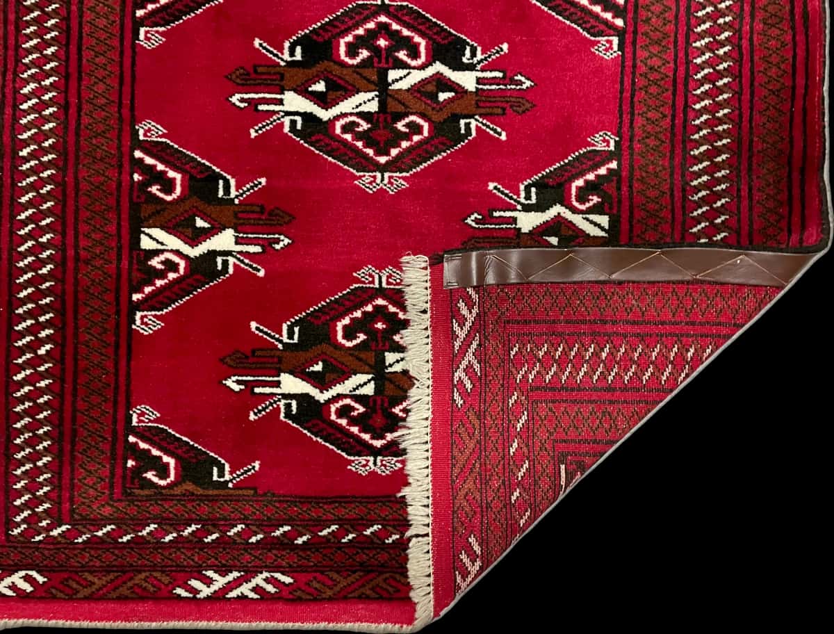 persischer Teppich im turkmenischer Stil in den Maßen 150 Zentimeter Länge mal 98 Zentimeter Breite mit überwiegend rot Farben — Gefaltet