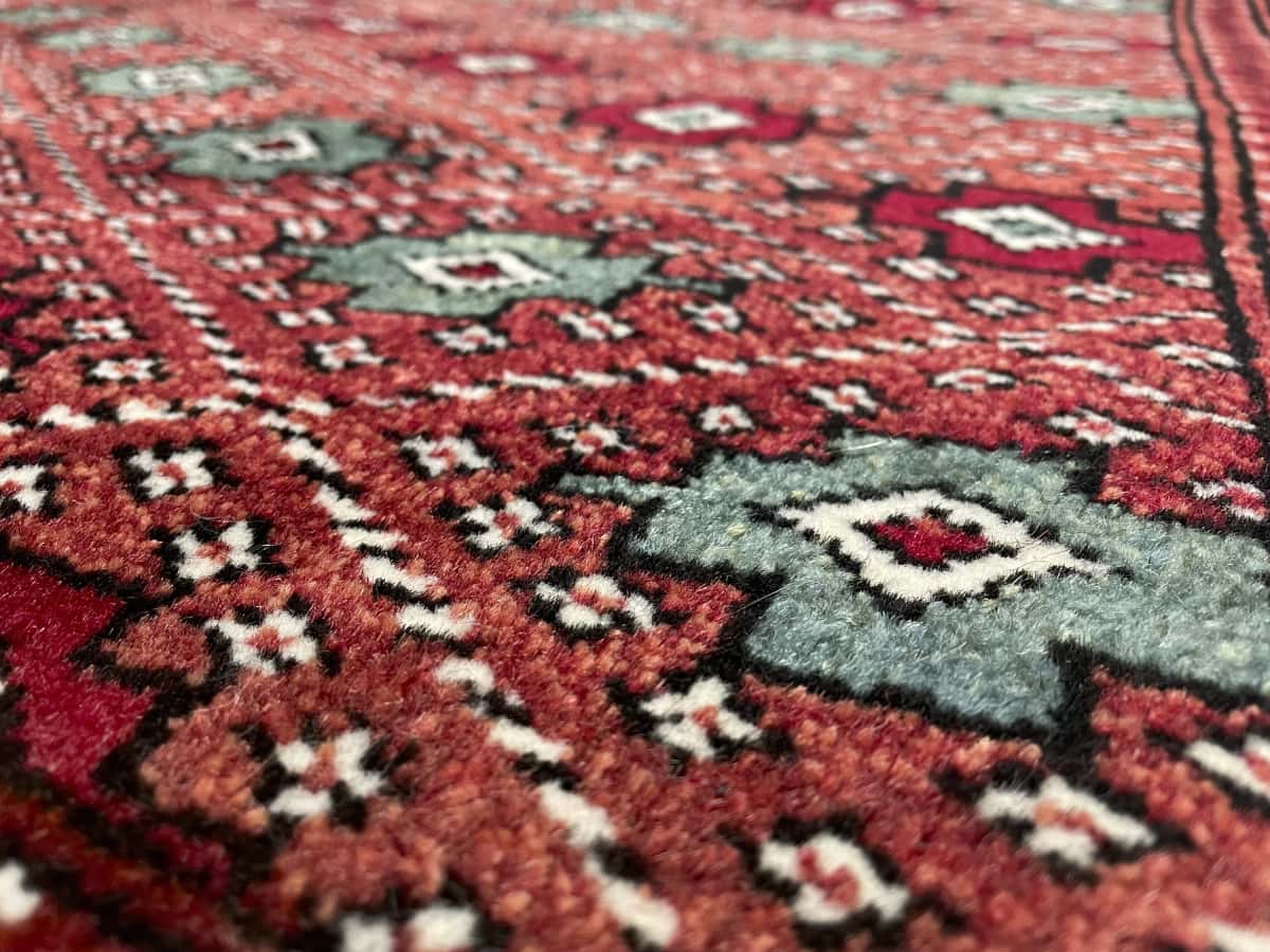 Persian rug of Turkoman style in dimensions 150 centimeters length by 102 centimeters width with mainly brown and red colors — Texture close-up