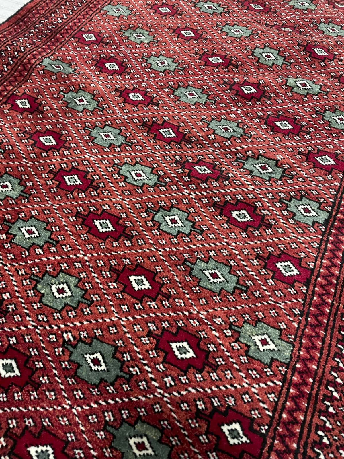 Persian rug of Turkoman style in dimensions 150 centimeters length by 102 centimeters width with mainly brown and red colors — Texture close-up