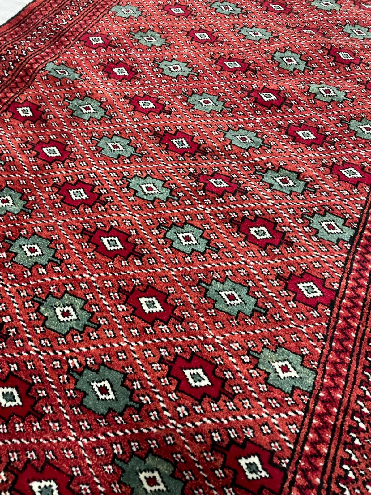 persischer Teppich im turkmenischer Stil in den Maßen 150 Zentimeter Länge mal 102 Zentimeter Breite mit überwiegend braun und rot Farben — Nahaufnahme der Textur