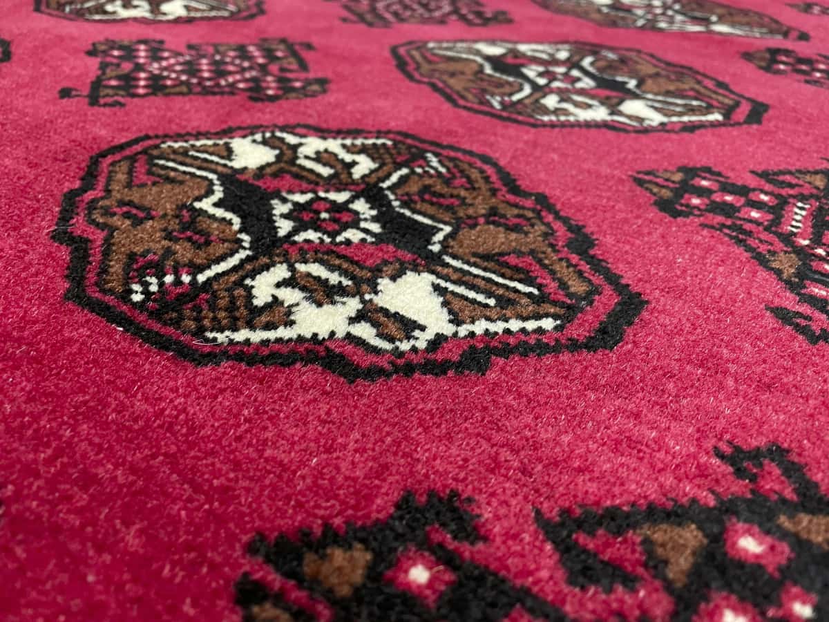 Persian rug of Turkoman style in dimensions 150 centimeters length by 104 centimeters width with mainly red colors — Texture close-up