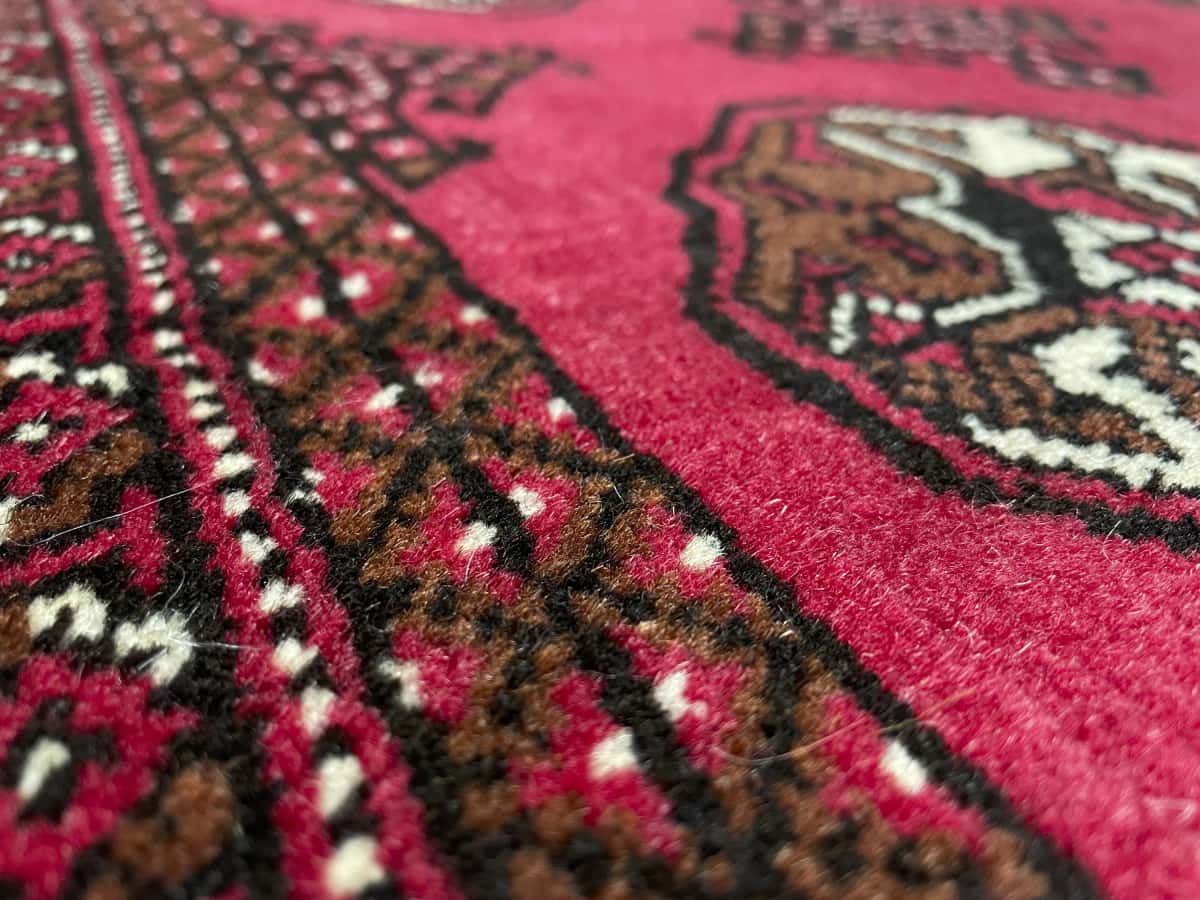 Persian rug of Turkoman style in dimensions 150 centimeters length by 104 centimeters width with mainly red colors — Texture close-up