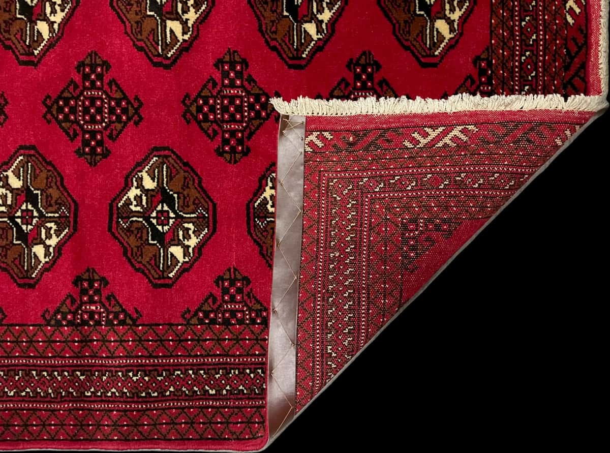 persischer Teppich im turkmenischer Stil in den Maßen 150 Zentimeter Länge mal 104 Zentimeter Breite mit überwiegend rot Farben — Gefaltet