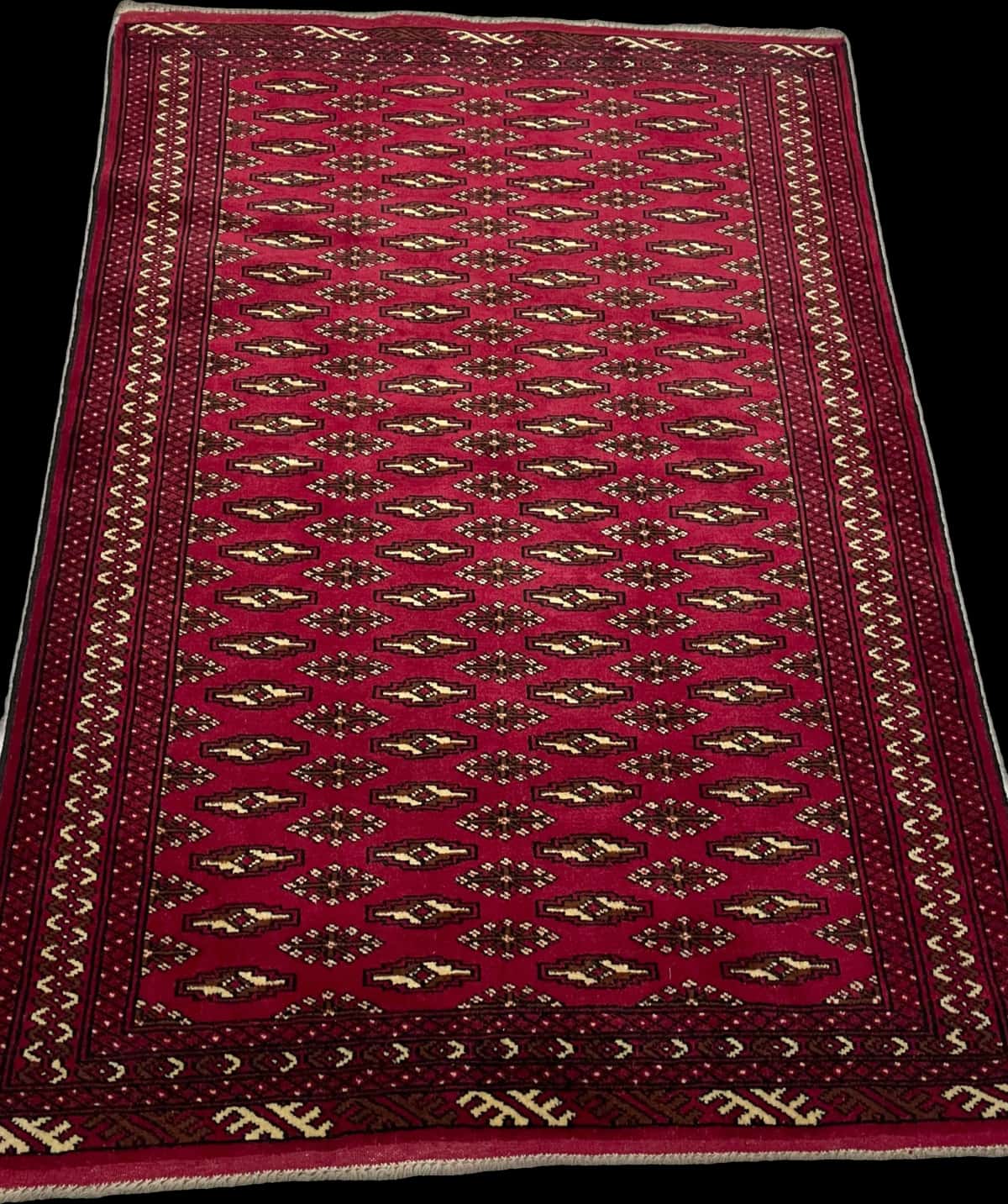 alfombra persa de estilo turcomana en dimensiones 148 centímetros de largo por 101 centímetros de ancho con colores principalmente rojo — Perspectiva