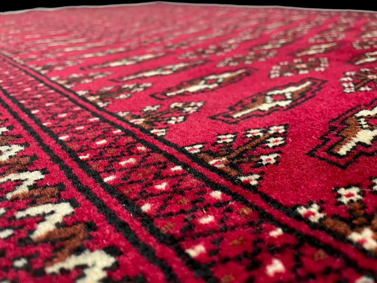 persischer Teppich im turkmenischer Stil in den Maßen 148 Zentimeter Länge mal 101 Zentimeter Breite mit überwiegend rot Farben — Nahaufnahme der Textur