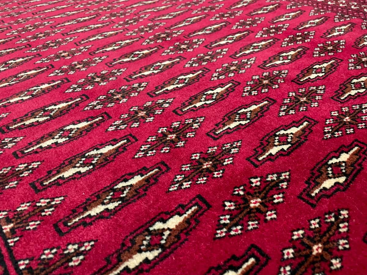 persischer Teppich im turkmenischer Stil in den Maßen 148 Zentimeter Länge mal 101 Zentimeter Breite mit überwiegend rot Farben — Nahaufnahme der Textur