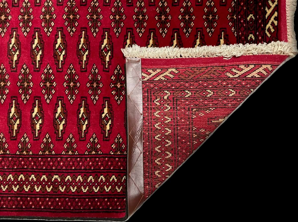 persischer Teppich im turkmenischer Stil in den Maßen 148 Zentimeter Länge mal 101 Zentimeter Breite mit überwiegend rot Farben — Gefaltet